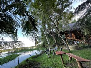 a wooden bench sitting next to a river at LakeSide Cabana Tissamaharama in Tissamaharama