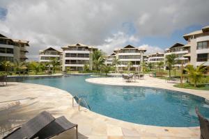 a swimming pool in front of some apartment buildings at Beach Place Resort Bangalo 12 in Aquiraz