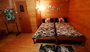 a bedroom with a bed in a wooden room at Chatki Sypialne Traperki in Polańczyk