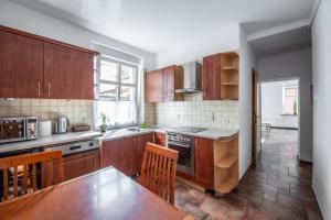 a kitchen with wooden cabinets and a table and chairs at Apartament Średnia 16 in Gliwice