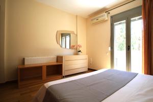 a bedroom with a bed and a dresser and a mirror at Loli's sea view apartment in Argostoli