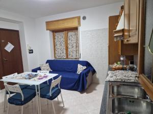 ein Wohnzimmer mit einem blauen Sofa und einem Tisch in der Unterkunft RaB&b in Contursi Terme