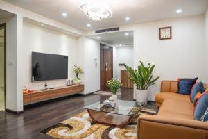 a living room with a television and a couch at Viet Vuong Building Ha Noi Capital in Hanoi