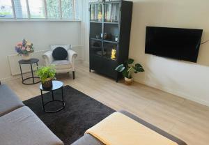 a living room with a couch and a flat screen tv at Souterrain Boslaan Katwijk aan zee in Katwijk aan Zee