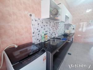 a kitchen with a sink and a stove top oven at Near TC Beach Alor Akar 4R3B fully AC Town area in Kuantan +9 photos