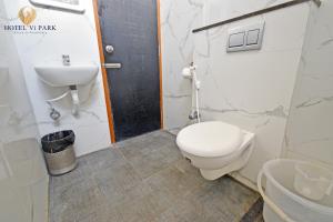 a bathroom with a toilet and a sink at Hotel Vi Park - City Centre in Puducherry