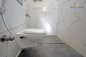 a bathroom with a white toilet in a room at Hotel Vi Park - City Centre in Puducherry
