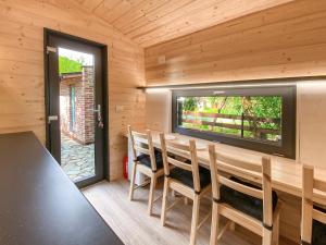 a dining room with a table and chairs and a window at Danube Microhouse in Divici