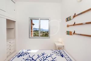 Un dormitorio blanco con una cama y una ventana. en VIllino Ginepro, en San Teodoro