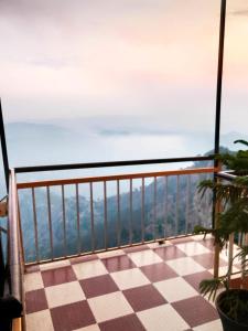 a view from a balcony with a checkered floor at Thakur Apartment in Shimla