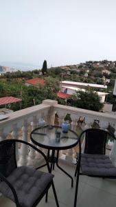 a table and chairs on a balcony with a view at ChristAlex Guesthouse in Himare