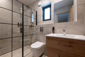a bathroom with a toilet and a sink and a shower at Asklipiou Cube - Kalamata Mediterranean Suites in Kalamata