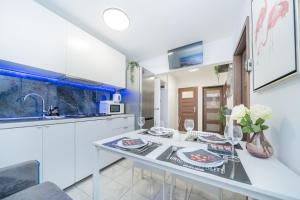 cocina blanca con mesa y fregadero en UNITApartament Short Rent Apartment in Warsaw by Metro Station Rondo ONZ Apart with 3bedrooms 22, en Varsovia