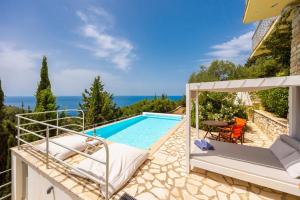 a villa with a pool and a view of the ocean at Villa Bougainvillea in Vlachopoulátika