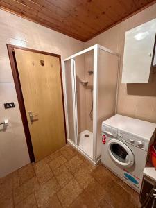 a washer and dryer in a bathroom with a toilet at Casa Defrancesco in Panchià