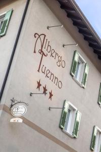 a sign on the side of a building with windows at Albergo Tuenno in Tuenno