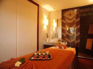 a room with a bed with a tray of food on it at Hansar Casuarina Cha am in Phetchaburi