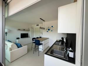 a kitchen and living room with a sink and a couch at A House with a view in Alassio