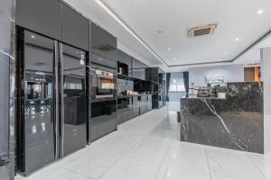 a large kitchen with black cabinets and marble counter tops at 芭堤雅最豪华的别墅十卧室十二卫生间 in Nong Prue
