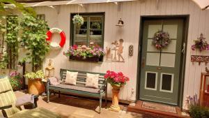 a porch with a green door and a bench and flowers at Gastehaus HH- Winterhude in Hamburg