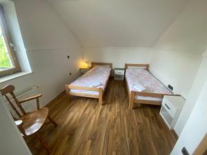 two beds in a small room with wooden floors at Countryside Apartment Agnes in Šentjošt nad Horjulom