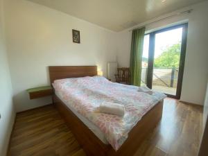 a bedroom with a bed and a large window at Countryside Apartment Agnes in Šentjošt nad Horjulom