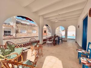 sala de estar con mesas y sillas y balcón en Lo Xalet de les Cases, en Les Cases d'Alcanar