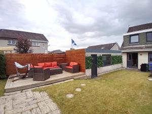 a backyard with a deck with a couch and a fence at Links Golf Villa in Troon