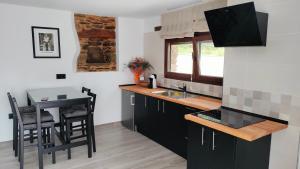 a kitchen with black cabinets and a small table at Val de ver in Pol