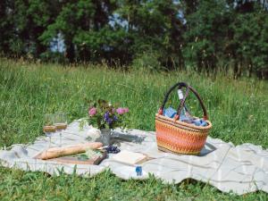 a picnic with a basket and wine glasses on a blanket at Sweetslade Cottage in Bourton on the Water