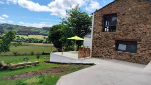 a building with a patio with a yellow umbrella at Val de ver in Pol