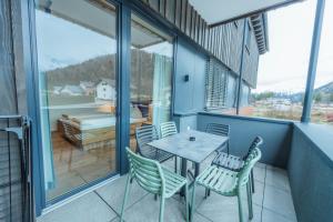 a patio with a table and chairs on a balcony at Ferienwohnungen Karlingerhof am See in Achenkirch