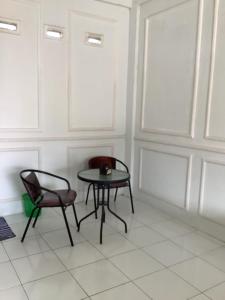 a room with a table and two chairs and a window at Minamo Homestay Modern Tengah Kota Payakumbuh in Payakumbuh