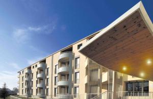 a large white building with a large wooden roof at Hotel Residence Zodiaco in Modena