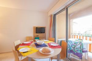 a dining room with a table with food on it at Pierre et Vacances Résidence Amandine in Saint-Tropez