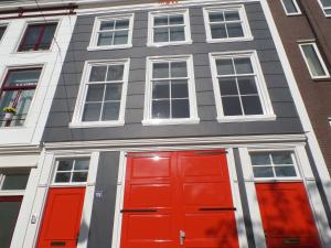 um edifício cinzento com portas e janelas vermelhas em MAFF Top Apartment em Haia