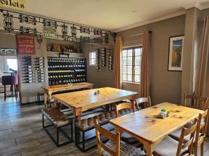 a restaurant with wooden tables and chairs and wine bottles at Sani Mountain Escape in Mokhotlong
