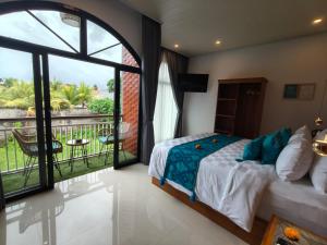 a bedroom with a bed and a view of a balcony at The Palms Canggu in Canggu