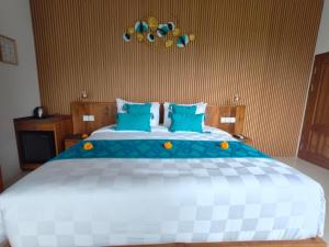 a bedroom with a large bed with blue pillows at The Palms Canggu in Canggu