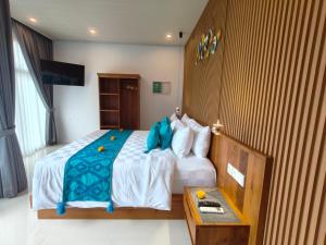a bedroom with a bed with a blue pillow on it at The Palms Canggu in Canggu