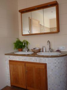 a bathroom with two sinks and a mirror at Naturhotel Goldene Zeit in Georgenberg