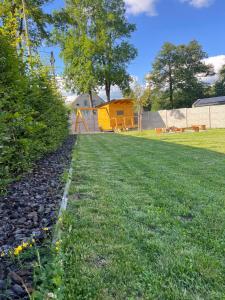 Un patio con césped y un parque infantil al fondo. en Chalupa na Bílé Vodě, en Červená Voda