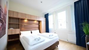 a bedroom with a large bed with two towels on it at Motel Plus Berlin in Berlin