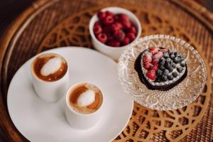 a plate with a dessert and two cups of coffee at Dom na Zaciszu Charzykowy in Charzykowy +68 photos