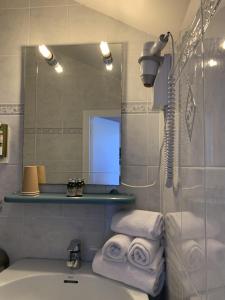 a bathroom with a sink and a mirror and towels at Hôtel U Pozzu in Sisco +94 photos