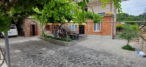 a courtyard of a house with a tree and chairs at Tsminda Giorgi Apartment in Sighnaghi