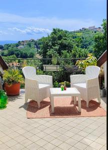 a white table and chairs on a patio with a view at Mansarda sul verde in San Giorgio Montagna