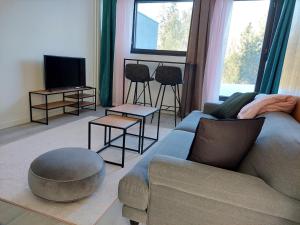 a living room with a couch and chairs and a tv at Gustavelund Apartments in Tuusula