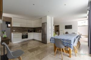 a kitchen and dining room with a table and chairs at Villa Iola a 150m de la playa ideal para familias y amigos in Playa de Muro