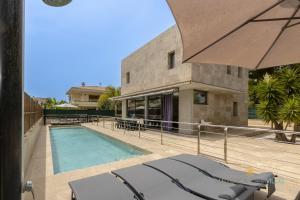 a house with a swimming pool next to a building at Villa Iola a 150m de la playa ideal para familias y amigos in Playa de Muro